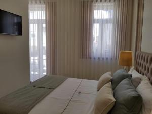 埃斯托利尔HÔTELS &ASPA的一间卧室设有一张大床、电视和窗户。