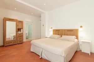 多马索B&B Villa Eden jacuzzi pool的卧室配有一张白色大床和镜子