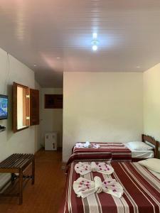 帕科蒂Estancia Vale das Flores的一间设有两张床铺和毛巾的房间