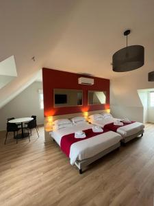 Pouzac比考尔乐杜梅纳高尔夫乡村俱乐部度假酒店的一间大卧室,配有两张床和一张桌子
