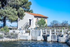 艾格-莫尔特MAS de COLOMINA Aigues-Mortes的一座有桥的建筑,在水体上