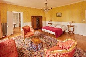 马恩河畔埃索姆玛乔莲城堡酒店的一间卧室配有一张床、一张沙发和椅子