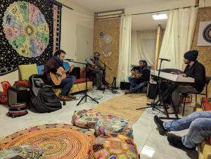 Dāliyat el Karmilאשראם בכרמל - אכסניה的一群坐在房间里播放音乐的人