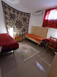 Dāliyat el Karmilאשראם בכרמל - אכסניה的客厅配有床和桌椅