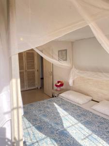 马林迪Ripasso Apartments的一间卧室配有一张带天蓬的大型白色床
