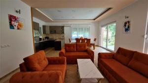 BunaHacienda Neretva的一间带两张沙发的客厅和一间厨房