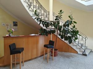 赫维兹Villa Lira的一间设有两张凳子和楼梯的等候室