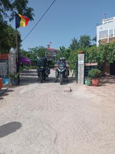 伊夫兰Motel Ain Mersa的两辆摩托车停在土路上,挂着旗帜