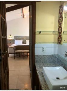 普拉亚多Casa Verde Apart - Aptos e Casa Residencial的一间带水槽的浴室和一间带一张床的卧室