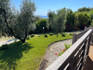 圣卢切Glamping Tuscany - Podere Cortesi的后院设有围栏和鲜花庭院