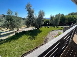 圣卢切Glamping Tuscany - Podere Cortesi的阳台享有花园景色。