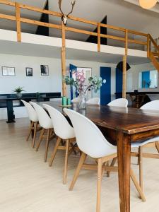 GadstrupCountry guesthouse的一间带木桌和白色椅子的用餐室