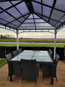 Maison au bord du canal的露台的遮阳伞下的桌椅