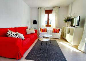 福斯Masquestar Rías Altas的客厅配有红色的沙发和两把椅子