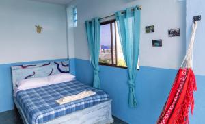 圣克里斯托瓦尔Mango Tree的一间卧室配有一张蓝色墙壁的床和一扇窗户