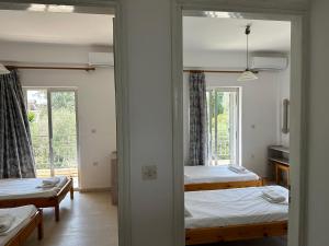 卡沃斯FULL HOUSE KAVOS的带两张床和镜子的客房
