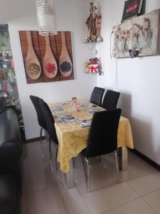 齐克拉约Residencial Las Torres de Salaverry的餐桌,墙上挂着黑色椅子和花瓶