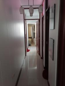 齐克拉约Residencial Las Torres de Salaverry的走廊通往一间铺有白色地板的客房