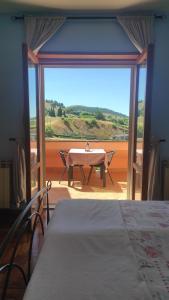 FilettoGran Sasso Letizia BB的客房设有桌子和大窗户。
