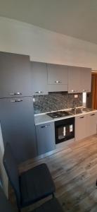 韦扎诺利古雷IN PANDORA'S BOX 5 LANDS的厨房配有白色橱柜和炉灶烤箱。