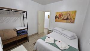 本图贡萨尔维斯Residência bem localizada em Bento Gonçalves的一间卧室设有两张床,墙上挂着一幅画