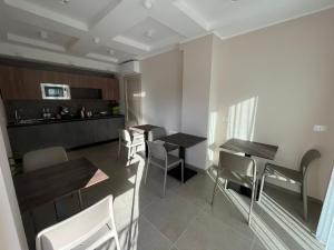 泰尔莫利Residenza Elba - Charme House的一间厨房和带两张桌子及椅子的用餐室