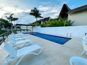巴卡拉尔Hotel Vista Laguna Bacalar的游泳池旁的一排躺椅
