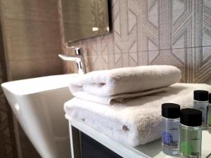科莫蒂尼Porcelani studio Komotini的浴室提供白色毛巾和水槽。