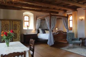 梅森Domherrenhaus Meissen的一间卧室配有一张天蓬床和一张桌子
