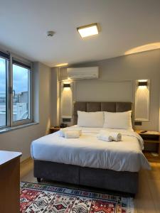 伊斯坦布尔Olen Uskudar Hotel的一间卧室配有一张大床和两条毛巾