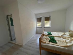 普里什蒂纳Rock Hostel的一间卧室设有一张床和两个窗户。