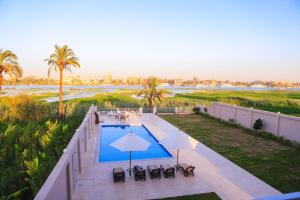 卢克索Royal Nile Villas - Pool View Apartment 1的享有带椅子和遮阳伞的游泳池的上方景致
