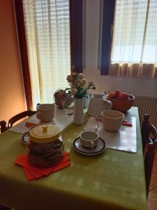 皮耶韦迪索利戈L'angolo di Anna的一张桌子,上面有绿桌布,上面有碗和杯子