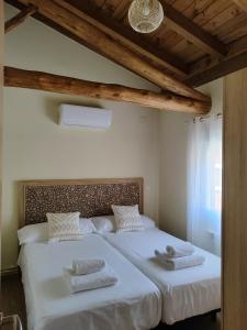 Castillo de BayuelaLa casita de Ra的一间卧室配有一张大床和毛巾