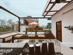 麦德林Rango Hostel Boutique的一个带桌椅的屋顶露台,享有城市美景