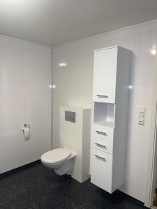 RødFamily-Friendly Apartment的一间带卫生间和白色橱柜的浴室