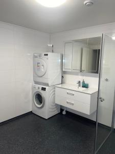 RødFamily-Friendly Apartment close to the beach的白色的浴室设有洗衣机和水槽。