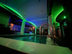 地拉那Hotel Rosa Blu的绿灯的建筑中的游泳池