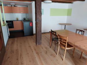 La Chaux-du-MilieuDrosera cabane et roulotte的厨房以及带木桌和椅子的用餐室。