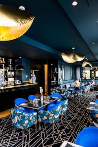 圣拉斐尔Hôtel le Touring的一间设有蓝色桌椅的餐厅和一间酒吧