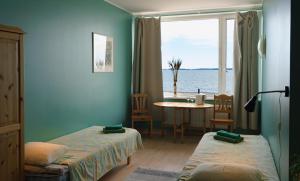 Viinistu维尼斯图艺术酒店的客房设有两张床、一张桌子和一扇窗户。