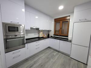 萨拉曼卡Casa albalunasss的厨房配有白色橱柜和不锈钢用具