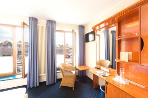 施特拉尔松德Hotel Kontorhaus Stralsund的酒店客房设有书桌和窗户。
