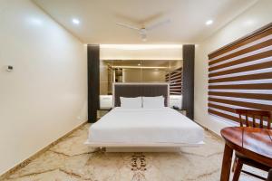 钦奈Palette - Coastal Grand Hotels & Resorts, OMR的卧室配有一张白色大床和一张书桌