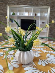 塔兰托CASA VACANZE : CASA FORTUNA的白色花瓶,桌子上放着黄色花