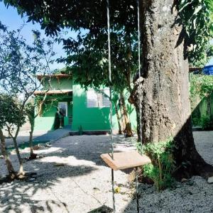 戈亚斯州上帕莱索Casa central aconchegante的挂在房子前面的树上的秋千