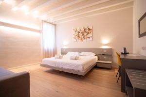 维罗纳Maison Calcirelli rooms的卧室配有白色的床和书桌