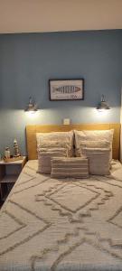 阿尔宗La Perle de l'Océan的一间卧室设有一张蓝色墙壁的大床