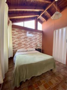 门多萨Open House Hostel的一间卧室设有一张床和砖墙