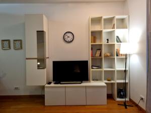 BežanijaUrban studio的客厅配有电视和墙上的时钟